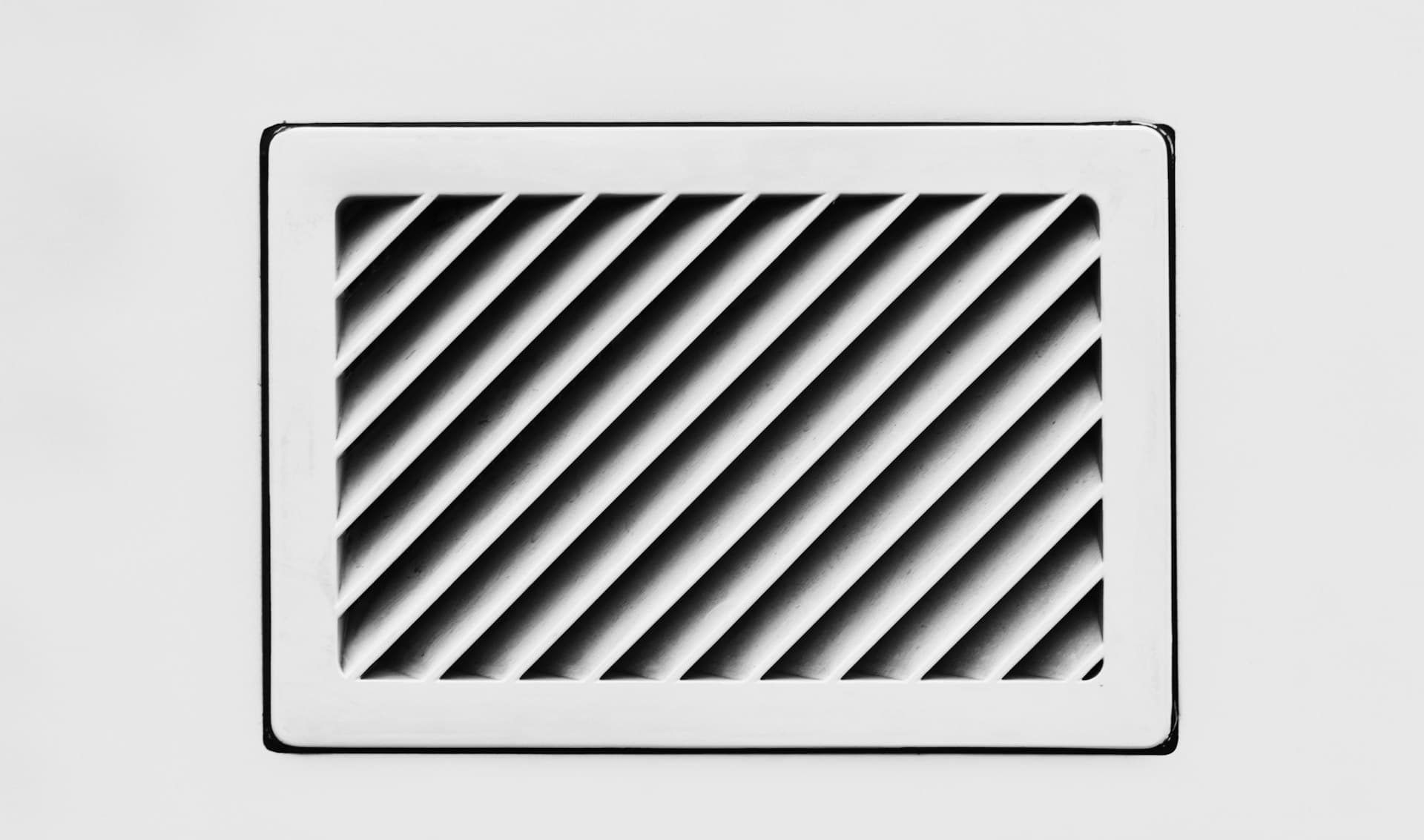A white return air vent on a wall
